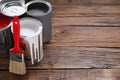 Cans of paints and brush on wooden table, space for text Royalty Free Stock Photo