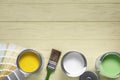 Cans of paints, palette and brush on wooden table, flat lay. Space for text Royalty Free Stock Photo