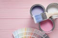 Cans of pastel paints, palette and brush on wooden table, flat lay. Space for text Royalty Free Stock Photo