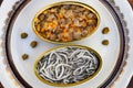 Cans of preserves with elvers and cockles Royalty Free Stock Photo