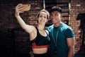 Cant leave the gym without a selfie. two young sportspeople taking a selfie together in a gym.