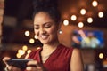 She cant survive without social media at her side. a young woman texting on a cellphone in a cafe. Royalty Free Stock Photo