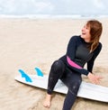 She cant wait to hit the water. A young female surfer getting ready to go out and enjoy the waves on a hot summers day.