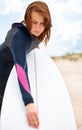 She cant wait to hit the water. A young female surfer getting ready to go out and enjoy the waves on a hot summers day. Royalty Free Stock Photo