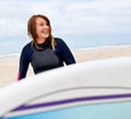 She cant wait to hit the water. A young female surfer getting ready to go out and enjoy the waves on a hot summers day. Royalty Free Stock Photo