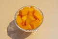 Cantaloupe fresh melon cubes in glass bowl on beige background. Organic vegetarian healthy food. Diet dessert fruit. Royalty Free Stock Photo