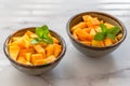 Cantaloupe melon bite-sized cubes close up in a bowls on light marble background. Royalty Free Stock Photo