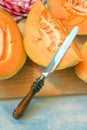 Cantaloupe melon slices and knife on rustic wooden table Royalty Free Stock Photo