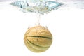 Cantaloupe melon splashing into water isolated on white background Royalty Free Stock Photo
