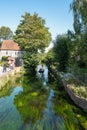 Canterbury, UK - Sep 27th 2020 Tourists enjoy a ride in a punt on the river Stour as it runs past the statue of the Bulkhead by