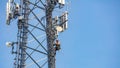 Communication maintenance. Technician climbing on telecom tower against blue sky background