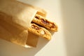 Cantucci cookies with candied fruits and nuts in a paper bag. White background, sunlight Royalty Free Stock Photo