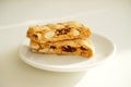 Cantucci cookies with candied fruits and nuts on a white plate. White background Royalty Free Stock Photo