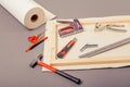 Canvas artist on roll, stretcher for canvas, staple gun and other tools on a gray background Royalty Free Stock Photo