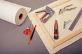 Canvas artist on roll, stretcher for canvas, staple gun and other tools on a gray background Royalty Free Stock Photo