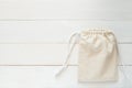 Canvas bag with drawstring, mockup of small eco sack made from natural cotton fabric cloth flat lay on white wood background from Royalty Free Stock Photo