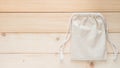 Canvas bag with drawstring, mockup of small eco sack made from natural cotton fabric cloth flat lay on white wood background Royalty Free Stock Photo