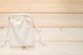 Canvas bag with drawstring, mockup of small eco sack made from natural cotton fabric cloth flat lay on white wood background from Royalty Free Stock Photo