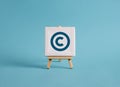 A canvas with copyright symbol on an easel with blue background