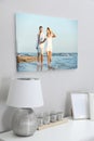 Canvas with printed photo of young couple on white wall in room Royalty Free Stock Photo