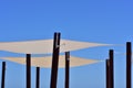 Canvas shades on black poles against the blue sky Royalty Free Stock Photo