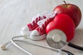 Canvas shoes, apple, stethoscope and red heart, diet and sport for healthy heart concept Royalty Free Stock Photo