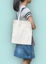 Canvas tote bag mockup cotton fabric texture on girl shoulderclipping path in white cream color isolated on blue background Royalty Free Stock Photo