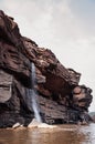 Canyon cliff shoreline and waterfall of Mekong river and local fisherman boat at Ban Pha Chan, Ubon Ratchathani - Thailand Royalty Free Stock Photo