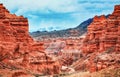 Canyon, mountain erosion, plateau, cloudy sky and mountains on the horizon. Red rocks and layers Royalty Free Stock Photo