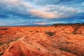 A canyon with rocks and red erosion, sunset sky, plateau, clouds. Royalty Free Stock Photo