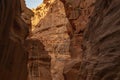 Canyon Siq or El Siq in Petra Jordan. Only road to rock city of Nabatean kingdom, to ancient city of Petra. Huge rocks hang over a Royalty Free Stock Photo