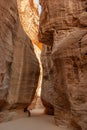 Canyon Siq or El Siq in Petra Jordan. Only road to rock city of Nabatean kingdom, to ancient city of Petra. Huge rocks hang over a Royalty Free Stock Photo