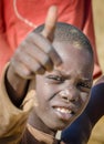 CAOTINHA, BENGUELA, ANGOLA - MAY 11 2014: Portrait of unidentified African boy with dirty face showing a thumbs up sign