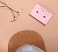 Cap, audio casset earphones on a brown background, music lover, minimalism, top view.