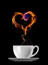 Cup of coffee with steam, heart symbol made of fire flames isolated on black background