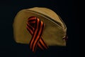 Cap with red star and George ribbon, headdress serviceman Red Army Soviet Union, on black background