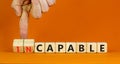 Capable or incapable symbol. Concept words Capable or Incapable on wooden cubes. Businessman hand. Beautiful orange table orange