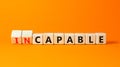 Capable or incapable symbol. Concept words Capable or Incapable on wooden cubes. Beautiful orange table orange background.