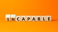 Capable or incapable symbol. Concept words Capable or Incapable on wooden cubes. Beautiful orange table orange background.