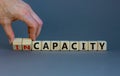 Capacity or incapacity symbol. Businessman turns wooden cubes and changes the word `incapacity` to `capacity`. Beautiful grey