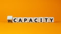 Capacity or incapacity symbol. Turned a wooden cube and changed the word `incapacity` to `capacity`. Beautiful orange backgrou