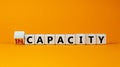 Capacity or incapacity symbol. Turned a wooden cube and changed the word `incapacity` to `capacity`. Beautiful orange backgrou