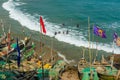 Cape Coast, Ghana - February 15, 2014: Colorful wooden fishing boats in African town Cape Coast and locals swimming Royalty Free Stock Photo