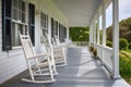 cape cod house with wraparound porch and rocking chairs Royalty Free Stock Photo