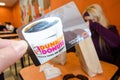 CAPE COD, MA: A hand holds up a Dunkin Donuts gift card inside of a Dunkin Donuts franchise store eating area