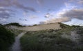 Cape Cod Rural Dunescape. The windswept and rugged landscape of sandy crater under dramatic clouds at sunset. Royalty Free Stock Photo