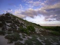 Dramatic cumulus cloudscape over the arid grass-covered sand dunes Royalty Free Stock Photo