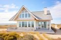 cape cod style with dormers on a beach dune with ocean in the background Royalty Free Stock Photo