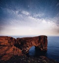 Cape Dyrholaey at southern Iceland. Altitude 120 m, and mean hill island with a door opening. Vibrant night sky with Royalty Free Stock Photo