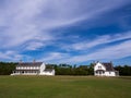 Cape Hatteras Principal Lighthouse Keeper\'s House and Museum of the Sea with beautiful clouds and a deep blue sky Royalty Free Stock Photo